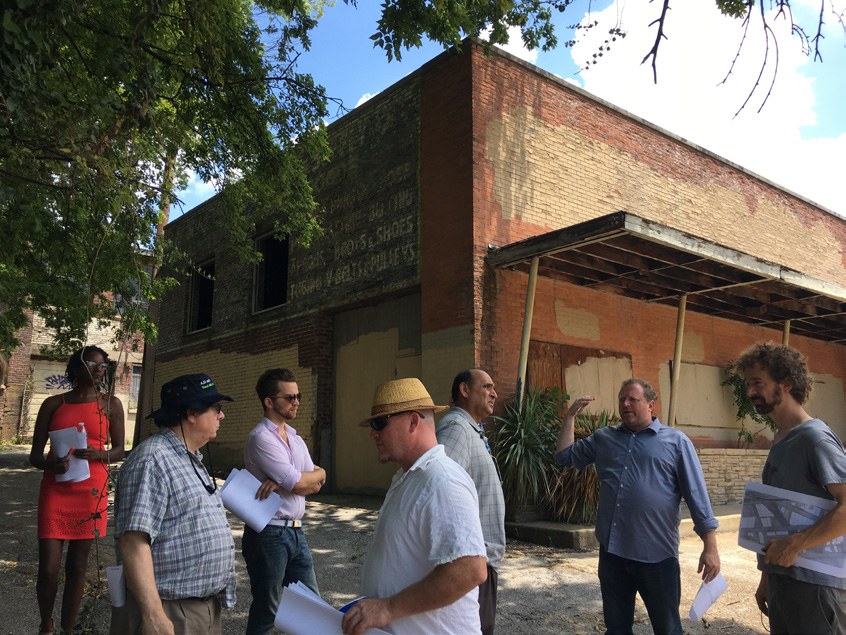 A walking tour and site discussion outside a historic Memphis storefront.